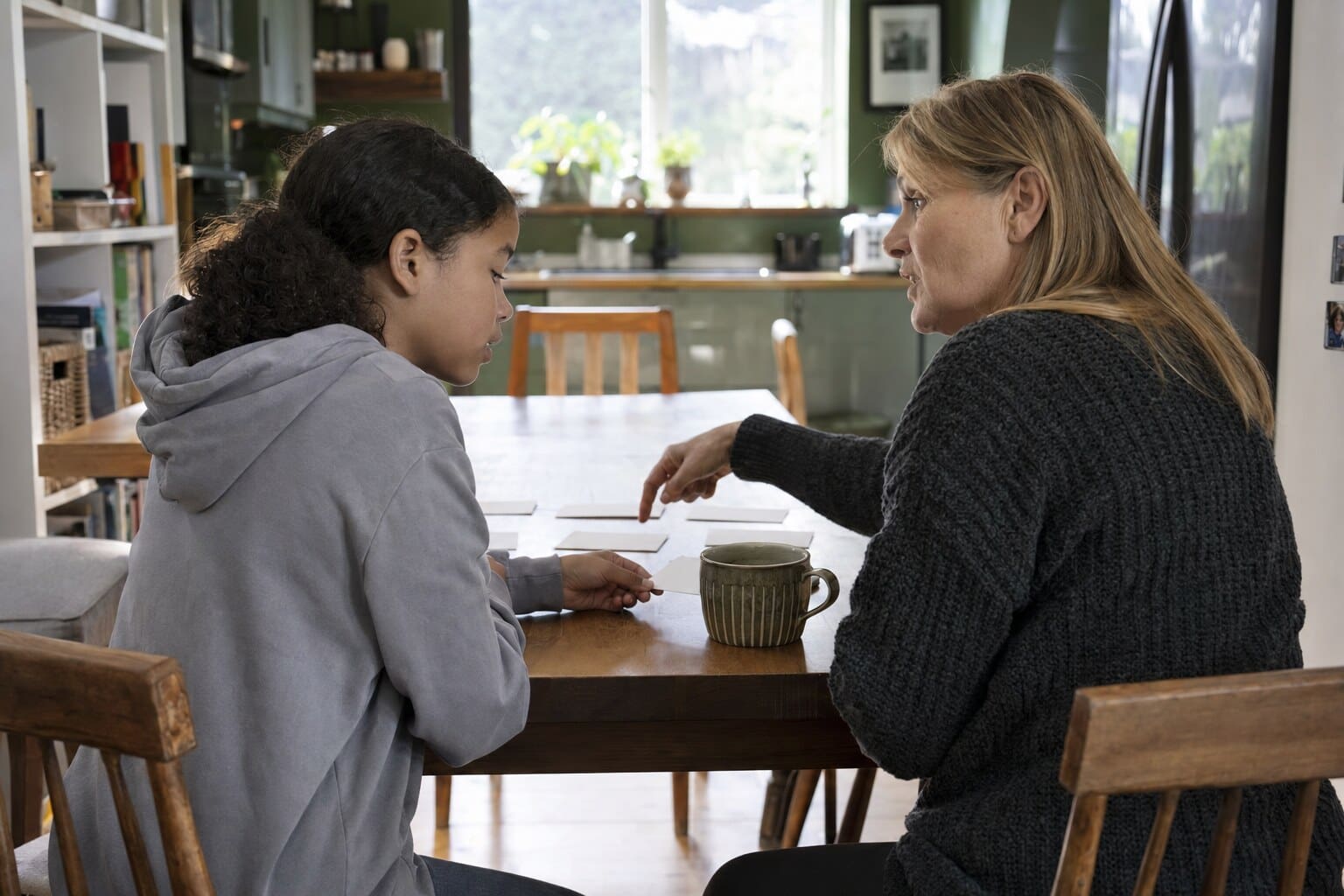 A foster carer sitting close with a young person, offering calm, steady support.